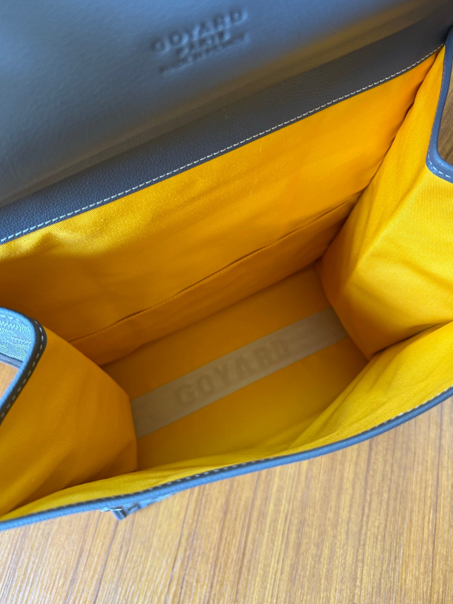 Yellow lined interior of a structured handbag with stitched side panels