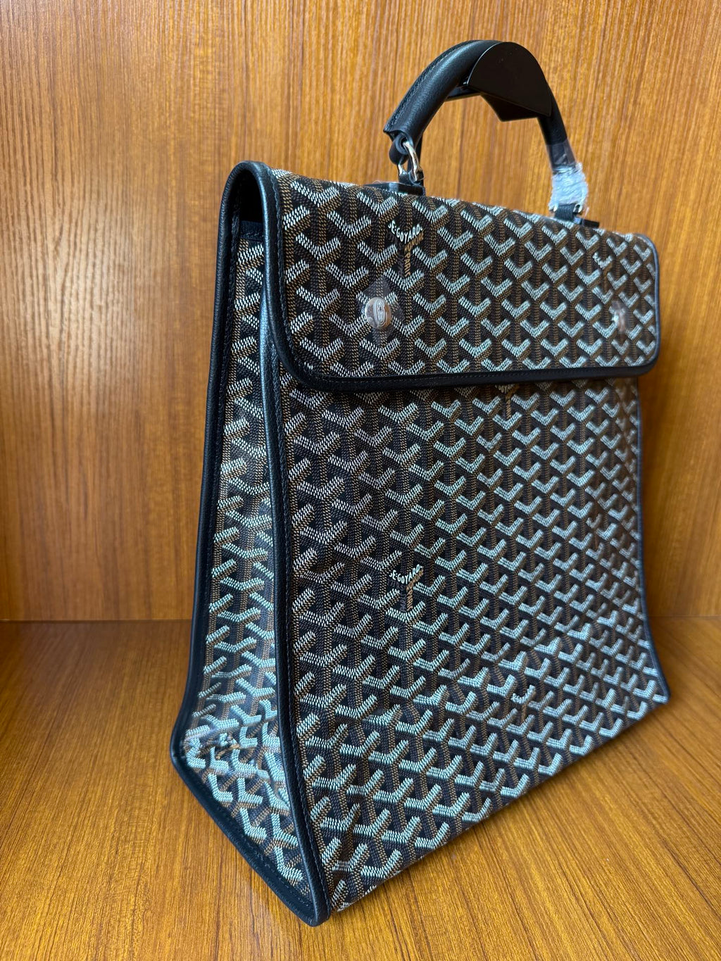 Goyardine patterned tote bag, side view, fold-over flap, dark blue-gray.
