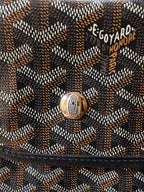 Logo patch on Goyardine patterned bag flap with metal snap hardware.