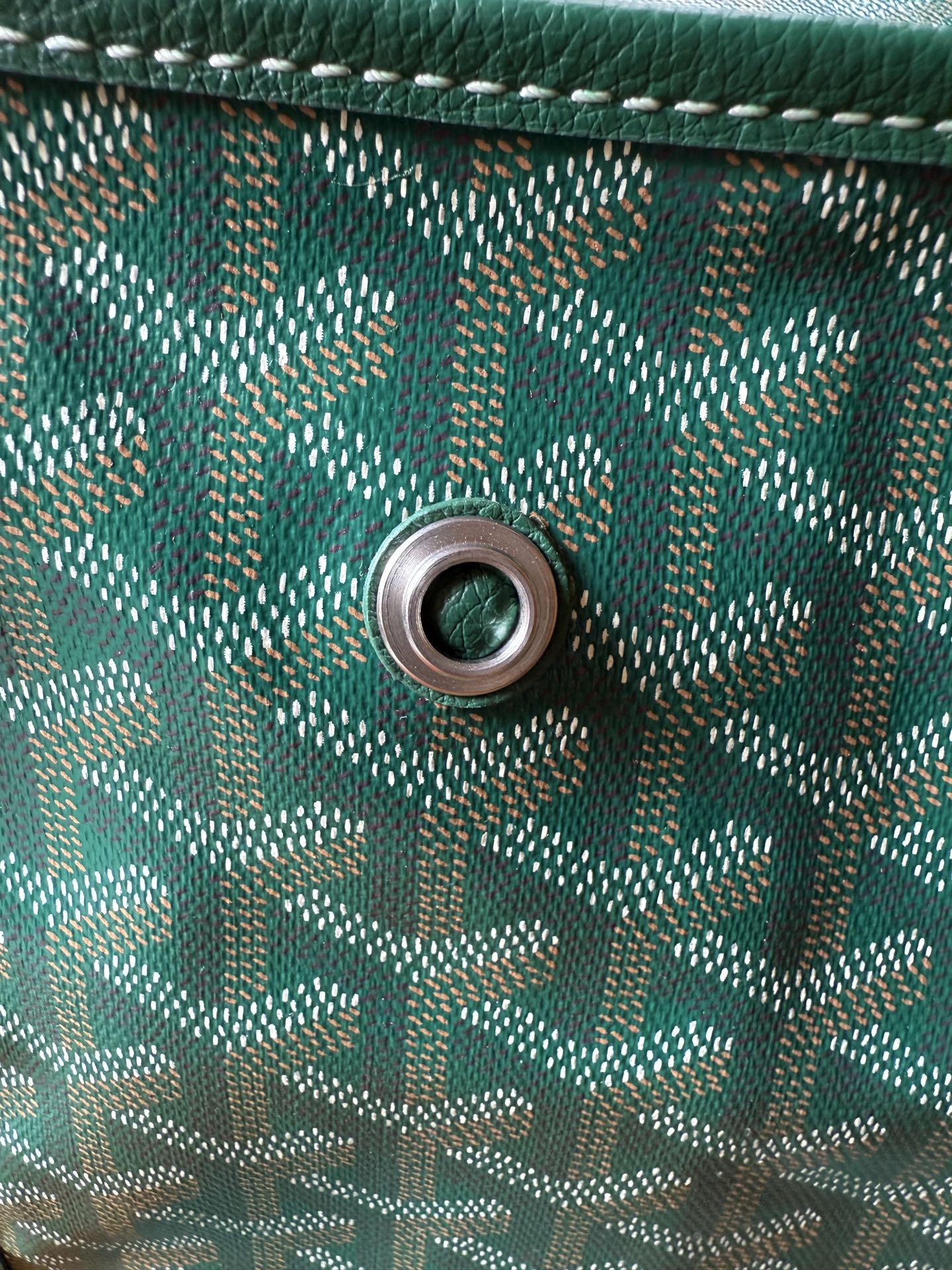 Teal patterned bag side with round eyelet for strap attachment