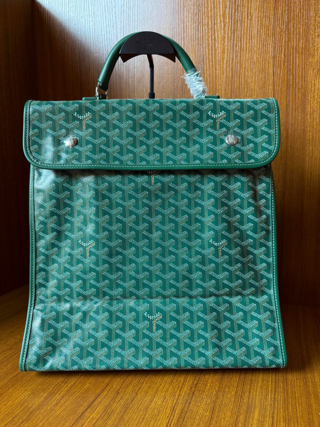 Teal patterned tote bag with flap, top handle, and silver-tone hardware