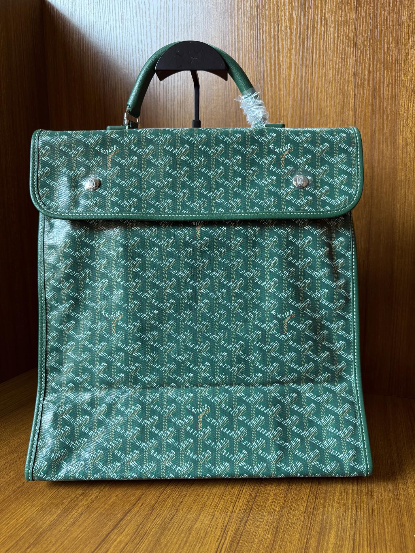 Teal patterned tote bag with flap, top handle, and silver-tone hardware
