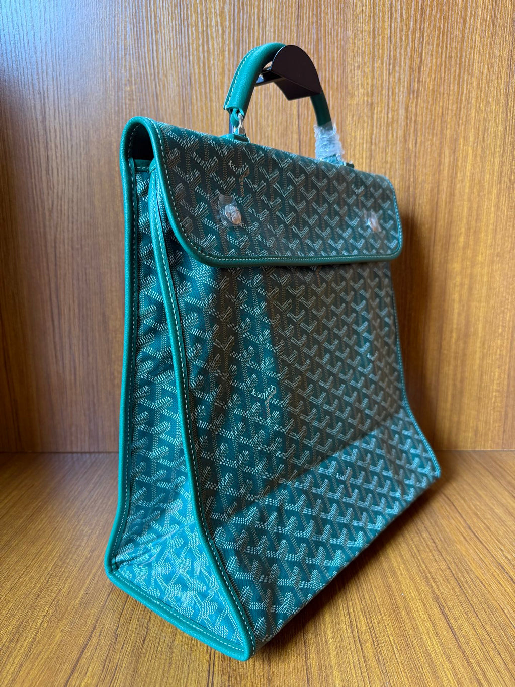 Teal patterned tote bag with top handle, side panel, and open flap