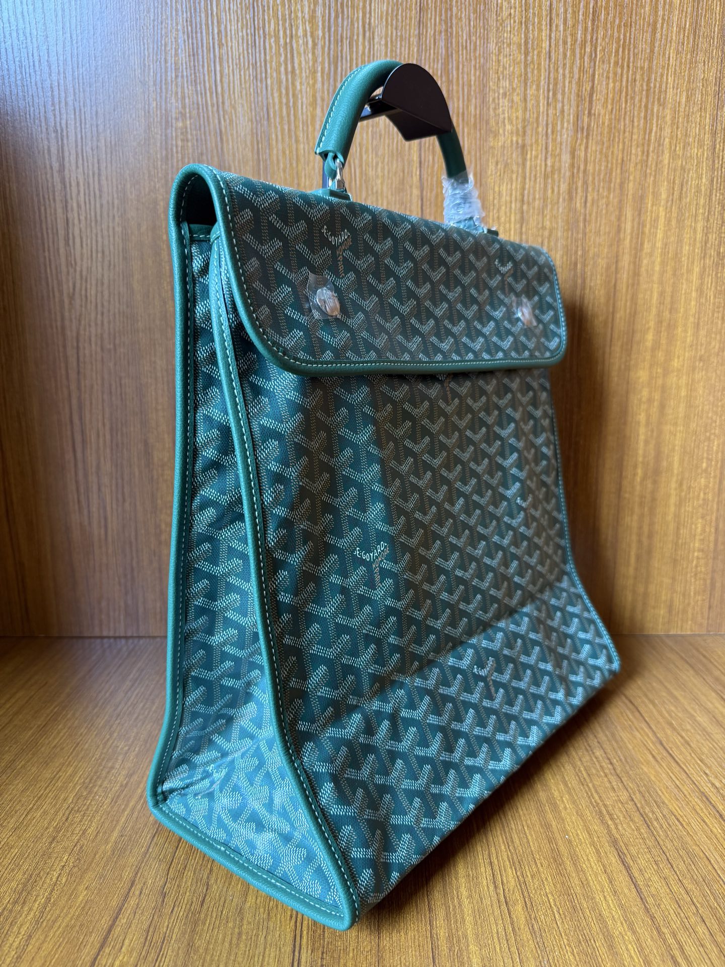 Teal patterned tote bag with top handle, side panel, and open flap