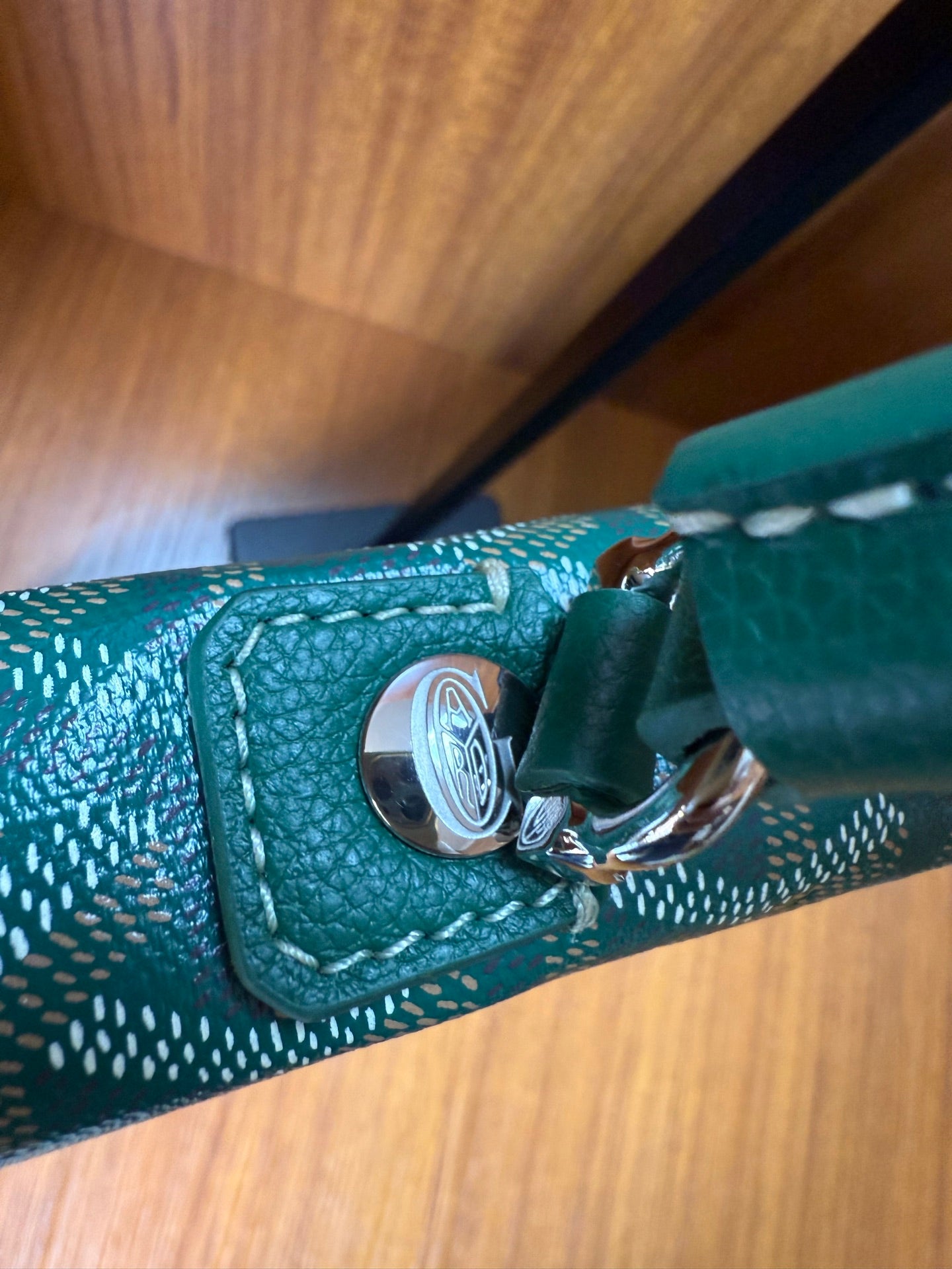 Teal leather handle with silver-tone hardware and snap button detail