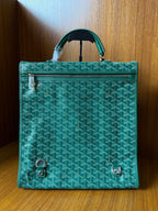 Teal patterned tote bag with top handle, flap, and silver-tone lock hardware