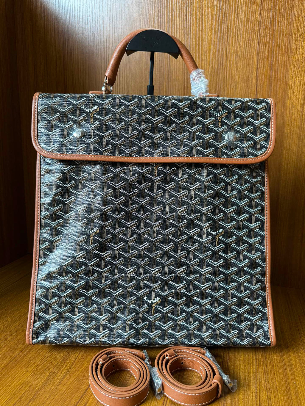 Designer tote bag with Goyard-style pattern, top handle, tan trim, and matching shoulder strap