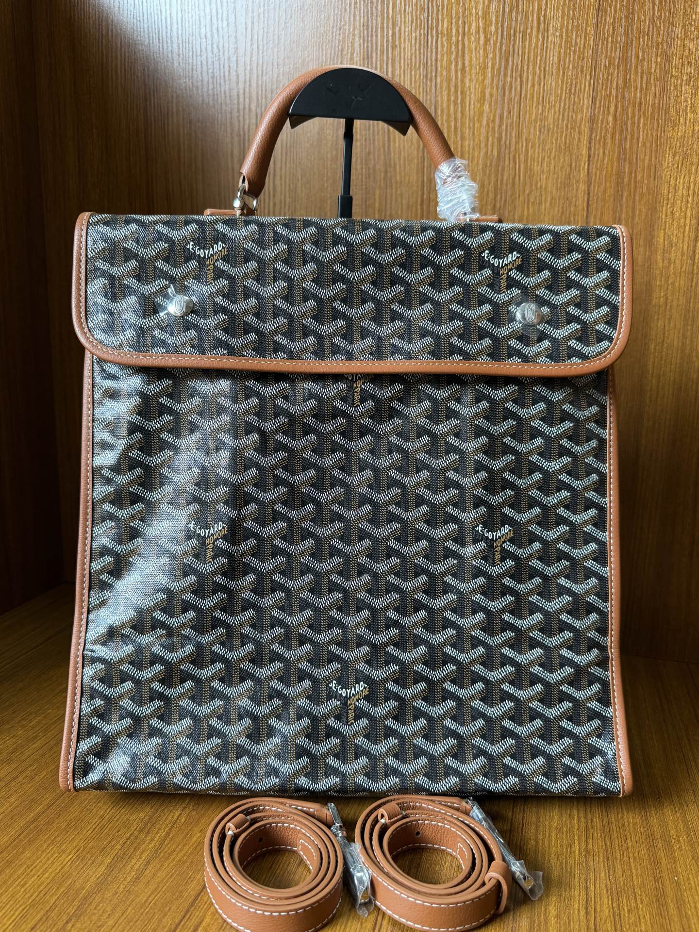 Designer tote bag with Goyard-style pattern, top handle, tan trim, and matching shoulder strap