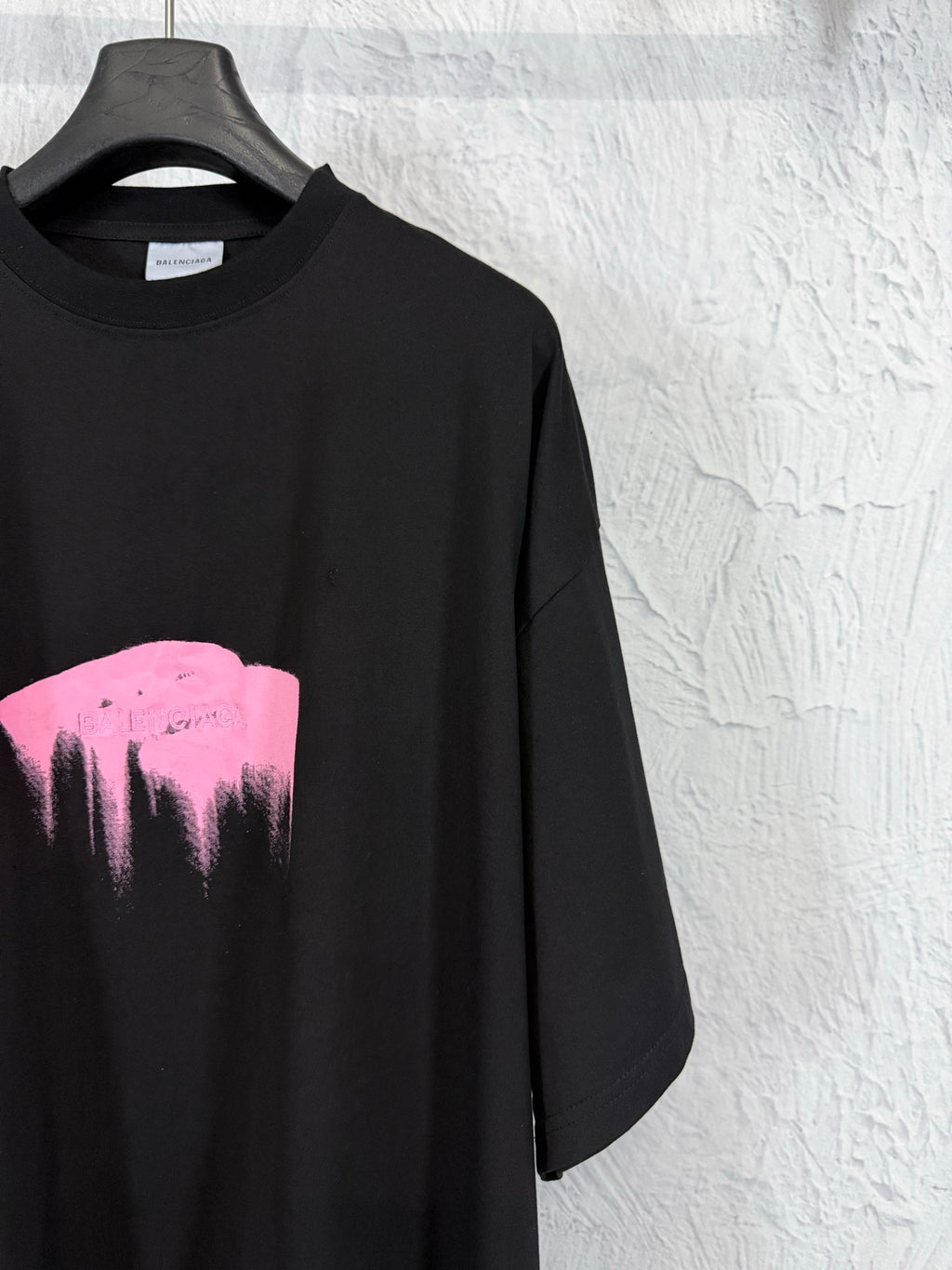 Balenciaga black T-shirt with partial pink heart graphic, close-up