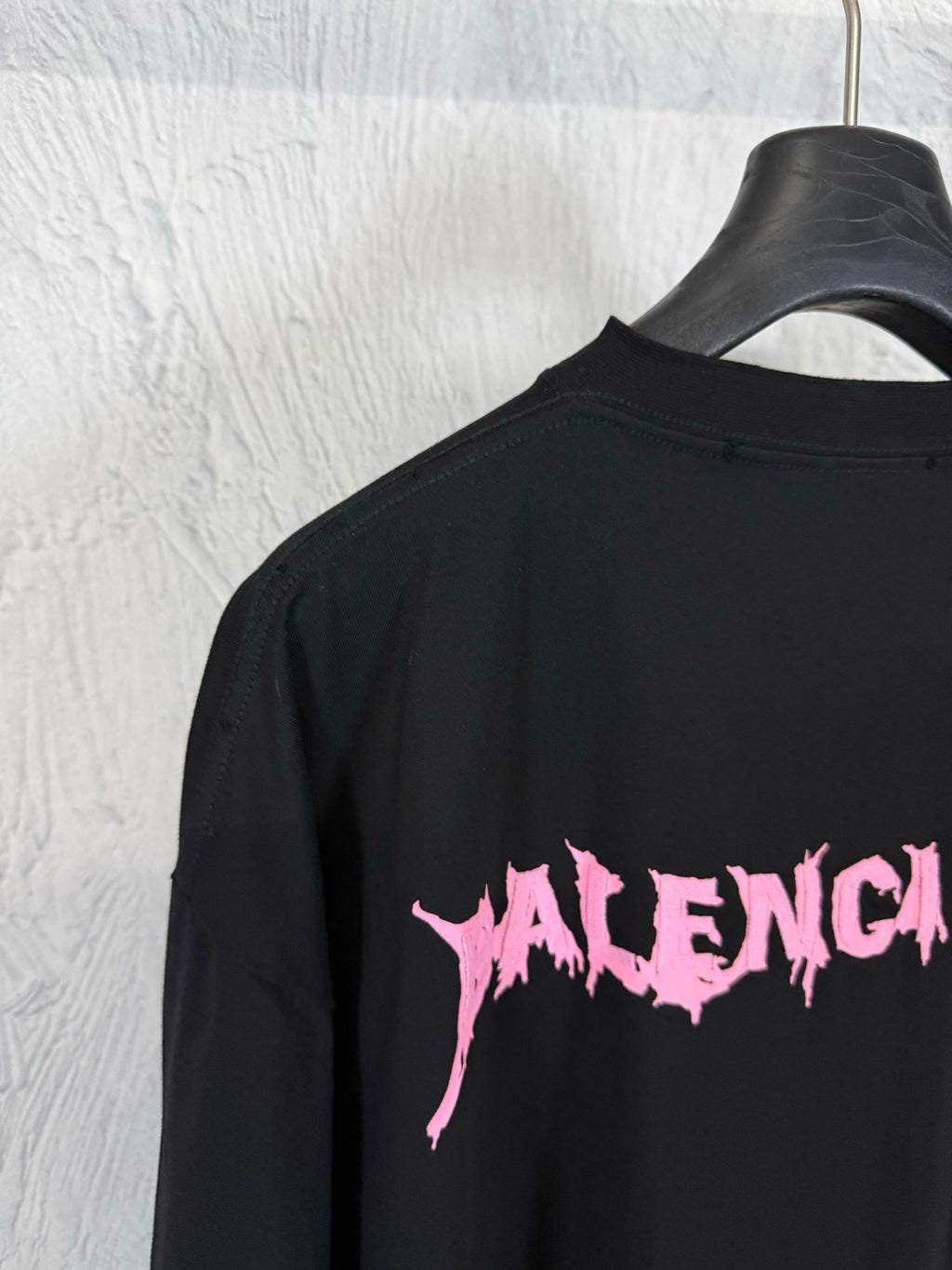 Black short-sleeve T-shirt with partial pink Balenciaga logo on the back