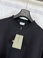 Black crew-neck T-shirt on hanger with small Balenciaga logo and hanging tag