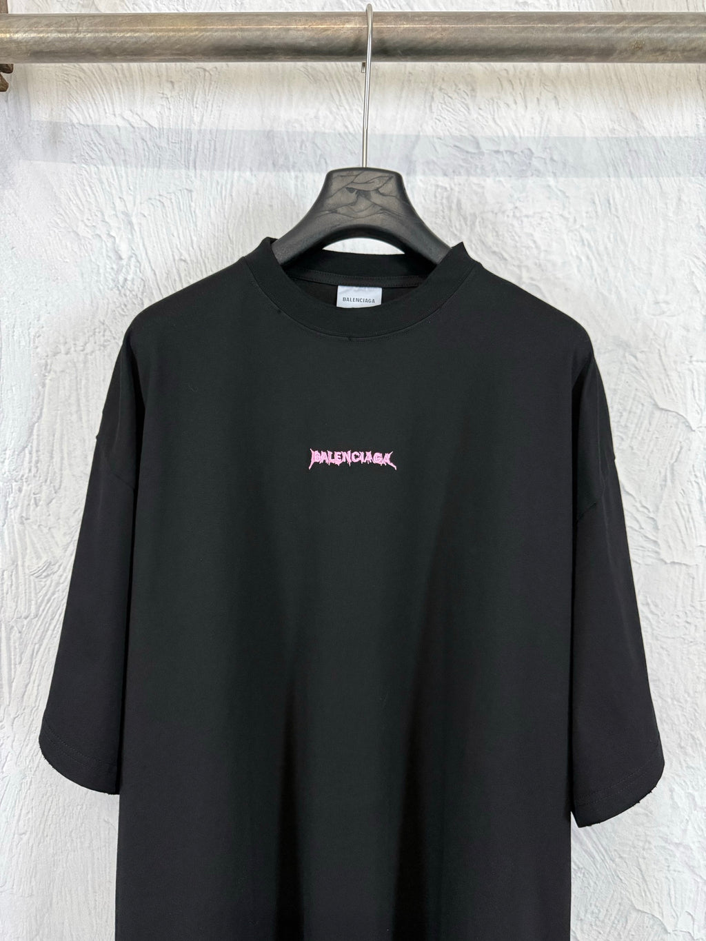 Black crew-neck short-sleeve T-shirt with small pink Balenciaga logo on the chest