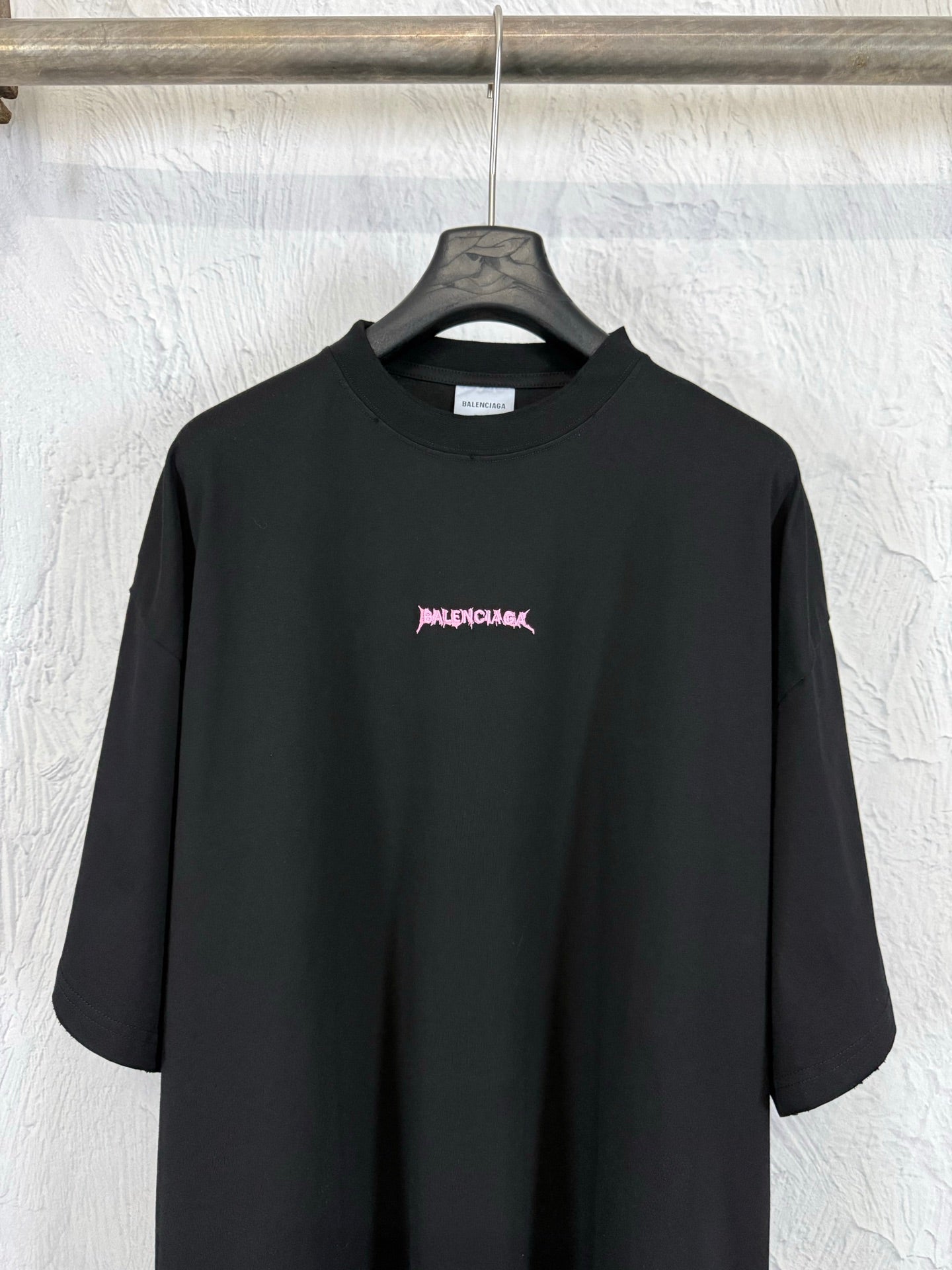 Black crew-neck short-sleeve T-shirt with small pink Balenciaga logo on the chest