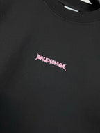 Black T-shirt chest logo detail in pink lettering