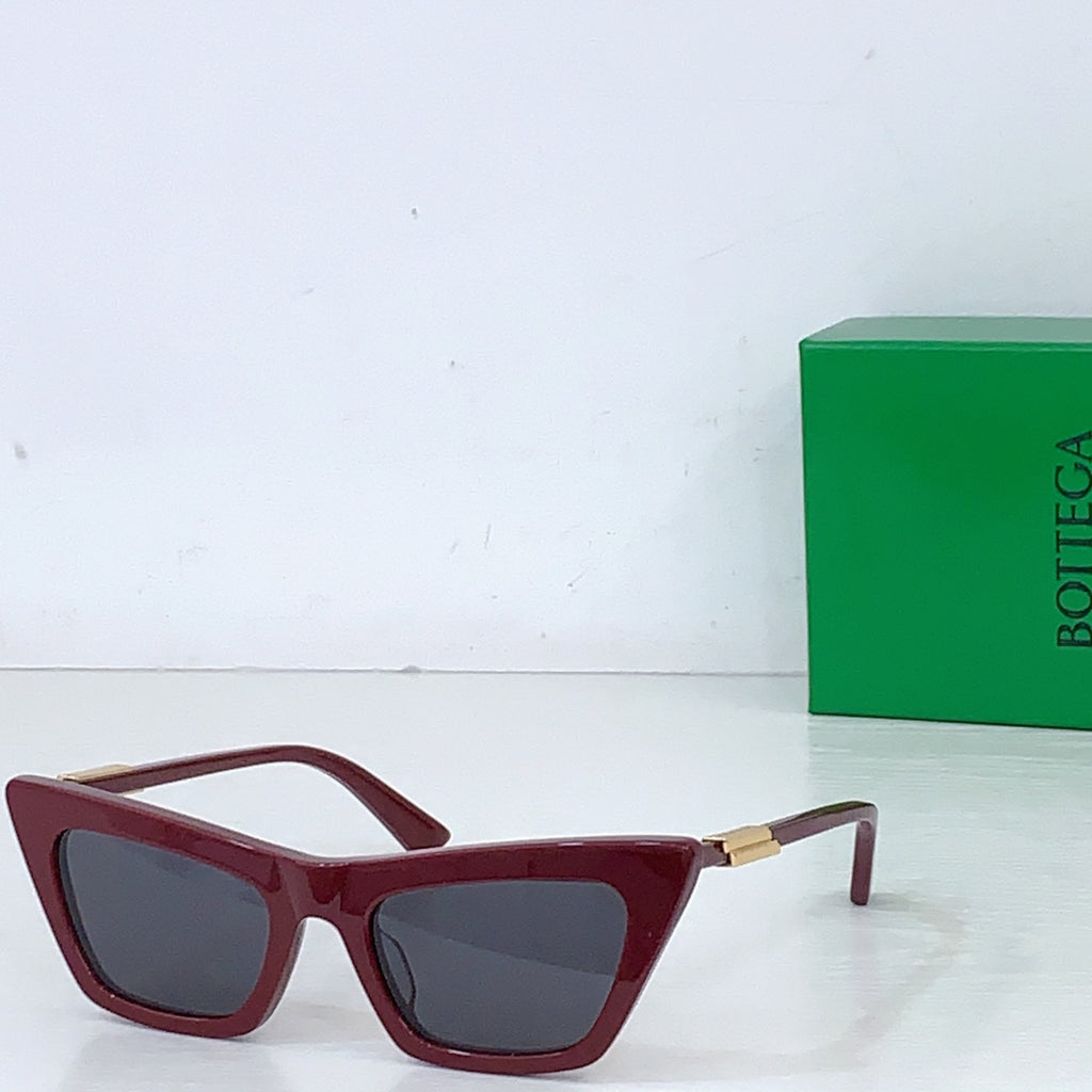 Sunglasses with burgundy cat-eye frame and dark lenses, gold-tone hinges