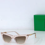 Sunglasses with clear blush cat-eye frame and light tan lenses, gold-tone hinges