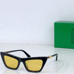 Sunglasses with black cat-eye frame and yellow lenses, gold-tone hinges