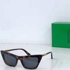 Sunglasses with tortoiseshell cat-eye frame and dark lenses, gold-tone hinges