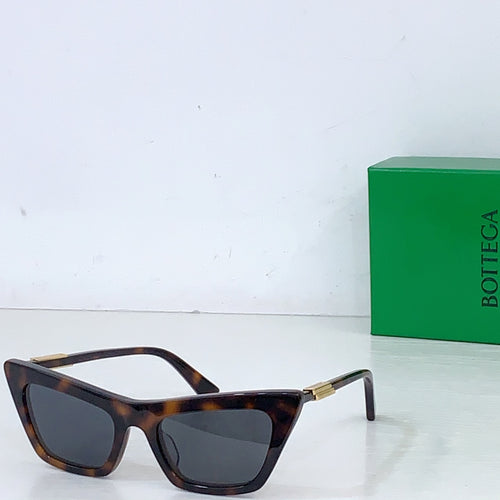 Sunglasses with tortoiseshell cat-eye frame and dark lenses, gold-tone hinges