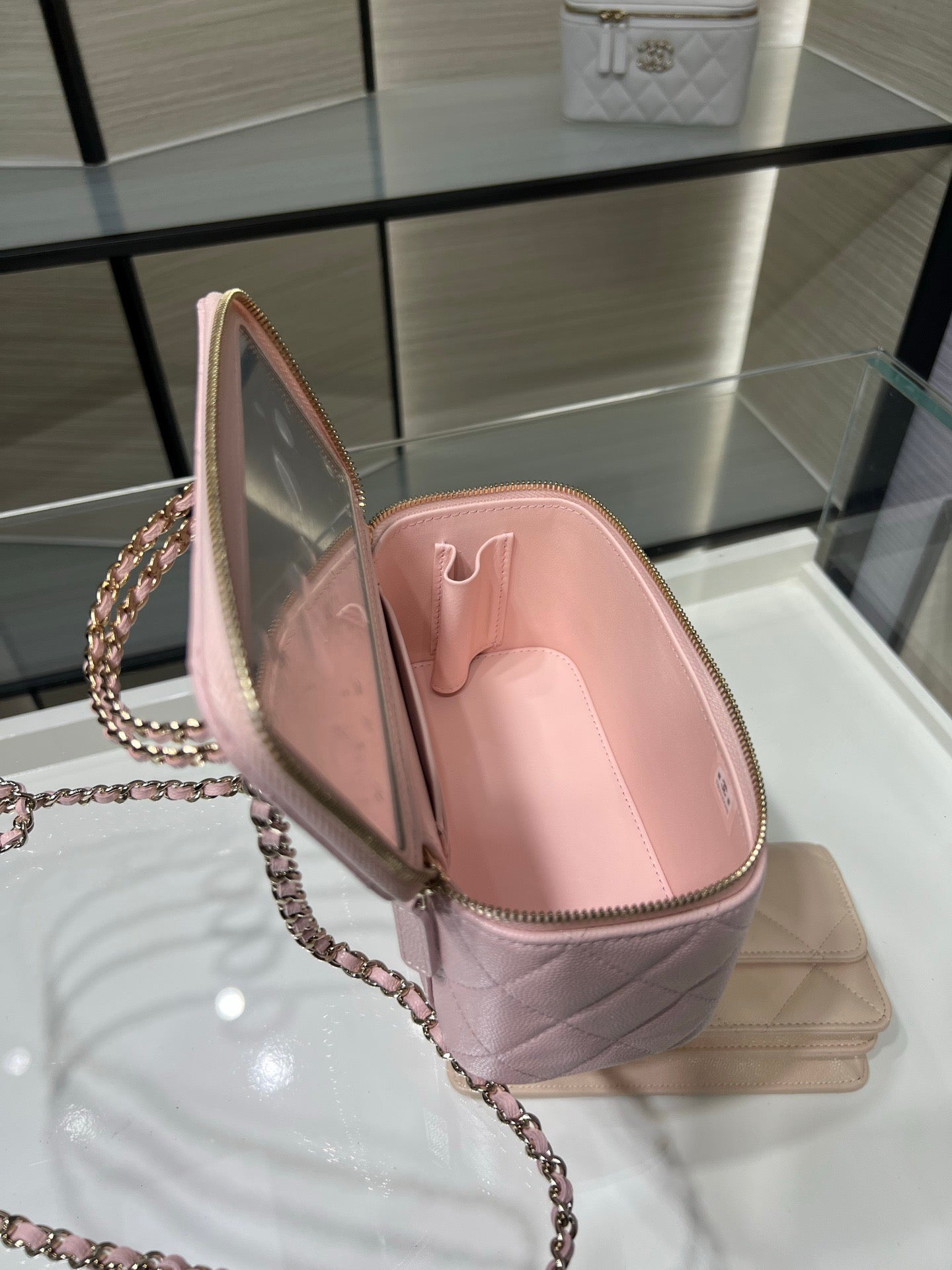 Chanel quilted mini bag in light pink shown open with zip lining and chain strap