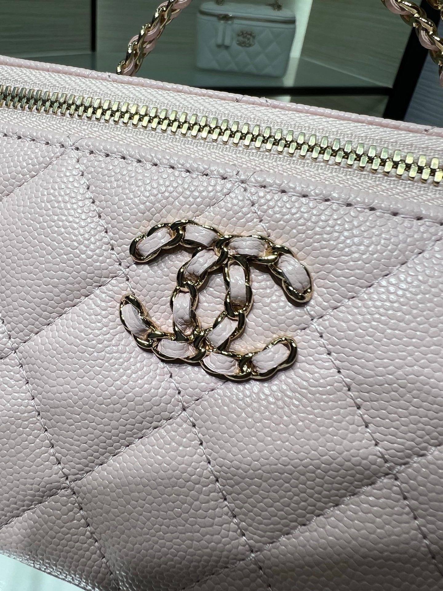 Chanel quilted bag close-up in white with metal CC emblem on front