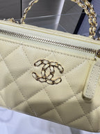 Chanel quilted bag close-up with silver-tone zipper and clasp detail in pale yellow
