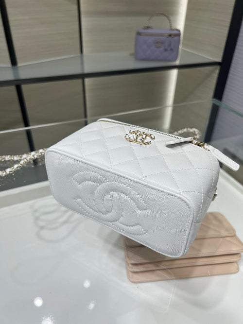 Chanel mini bag in white with quilted sides, chain handle, and top zipper closure.