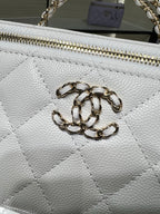 Chanel bag close-up: white textured leather with gold chain zipper pull and hardware.