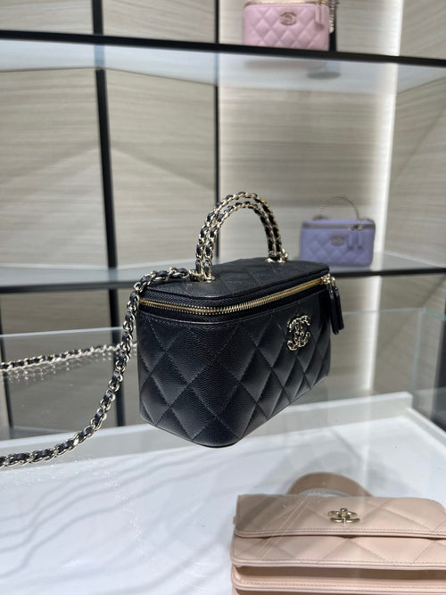 Quilted Chanel mini handbag with chain strap, top zip and gold-tone logo hardware.