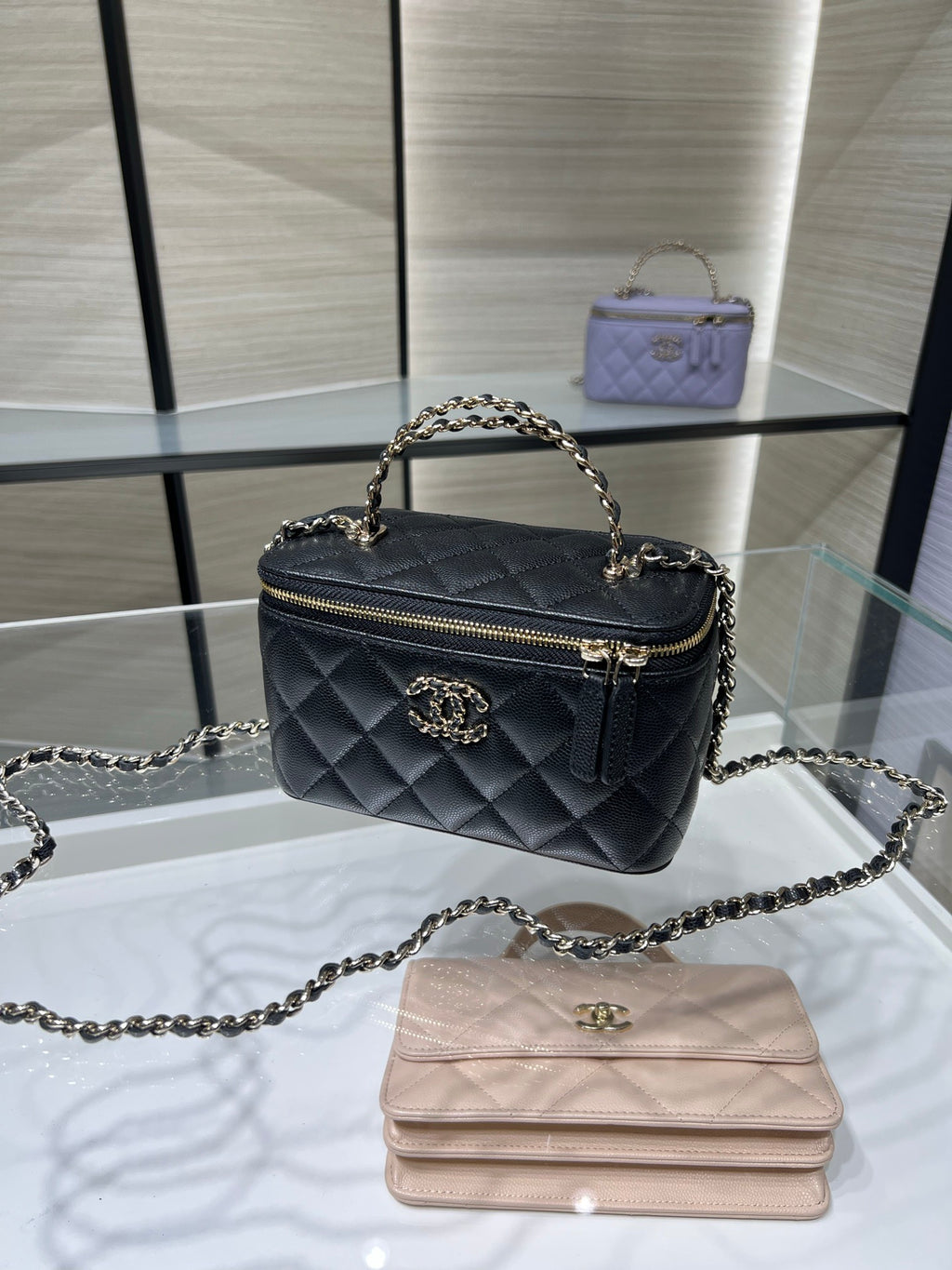 Quilted Chanel mini handbag with chain handle, top zip, and gold-tone logo emblem.