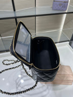 Chanel mini handbag open view with gold zipper, quilted interior and chain strap.