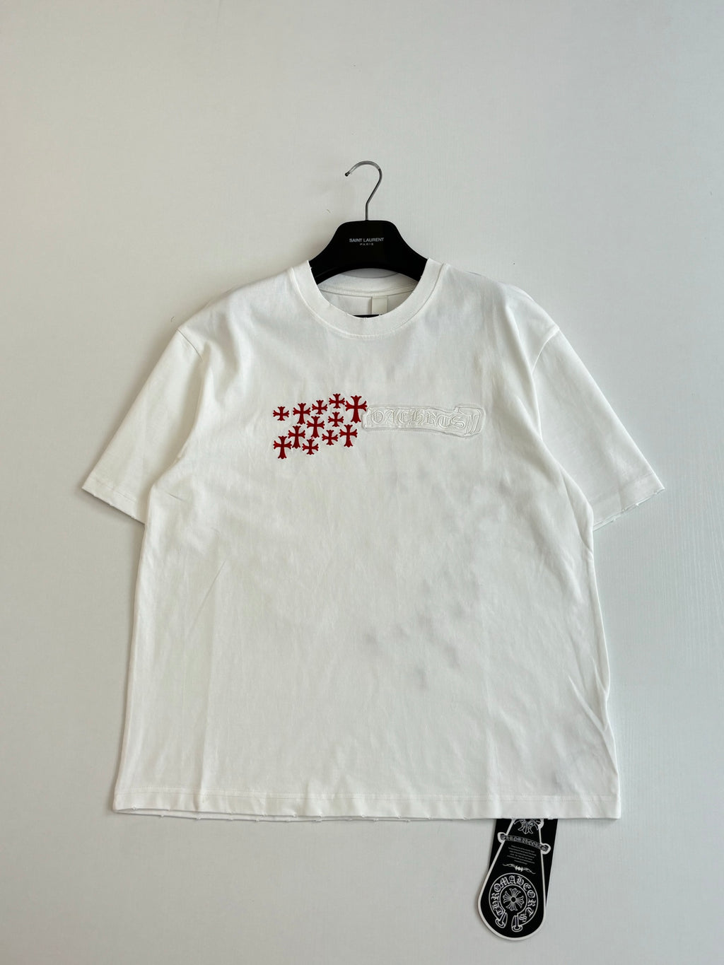 White short-sleeve T-shirt with small chest red logo and text detail