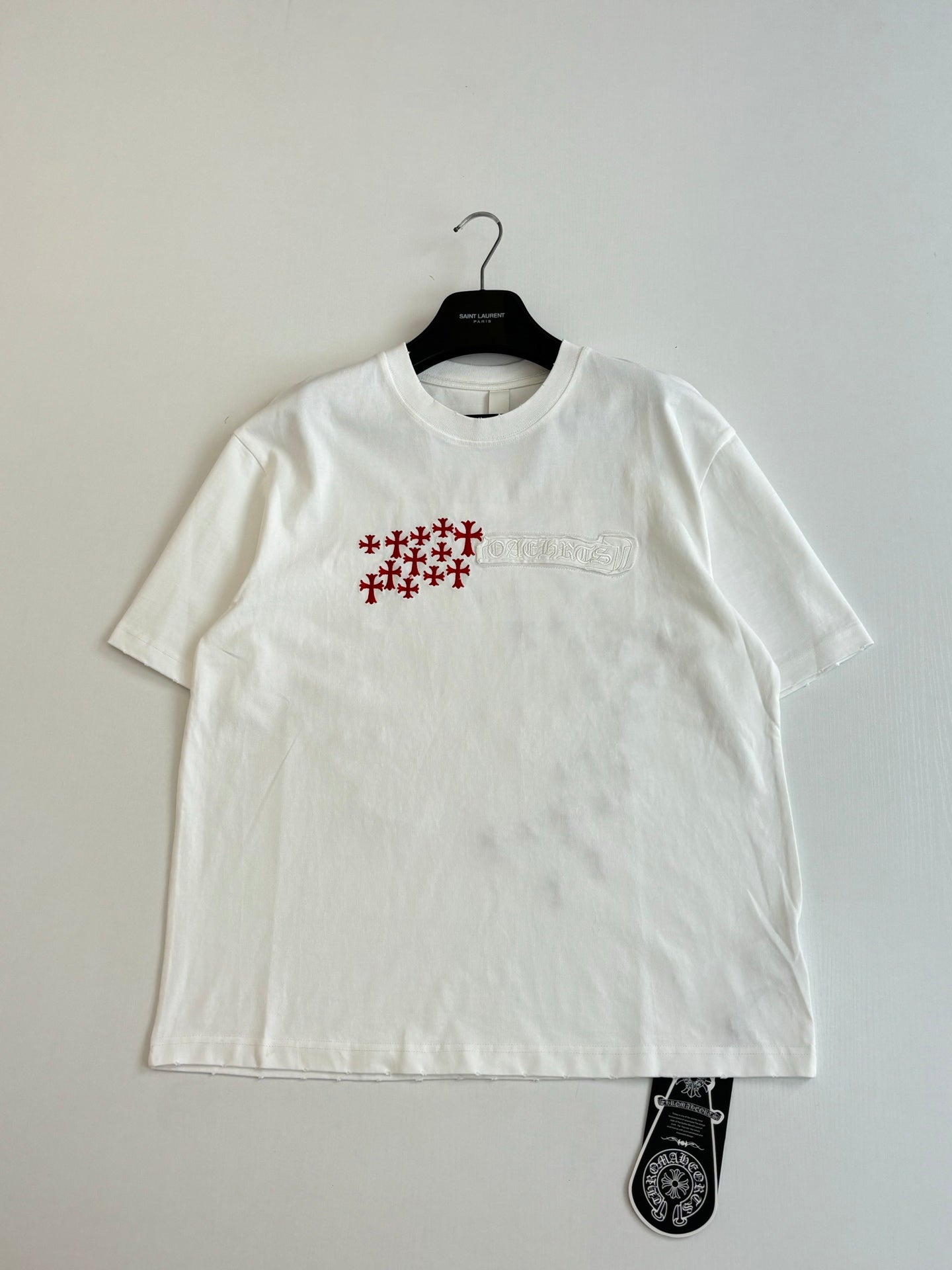 White short-sleeve T-shirt with small chest red logo and text detail
