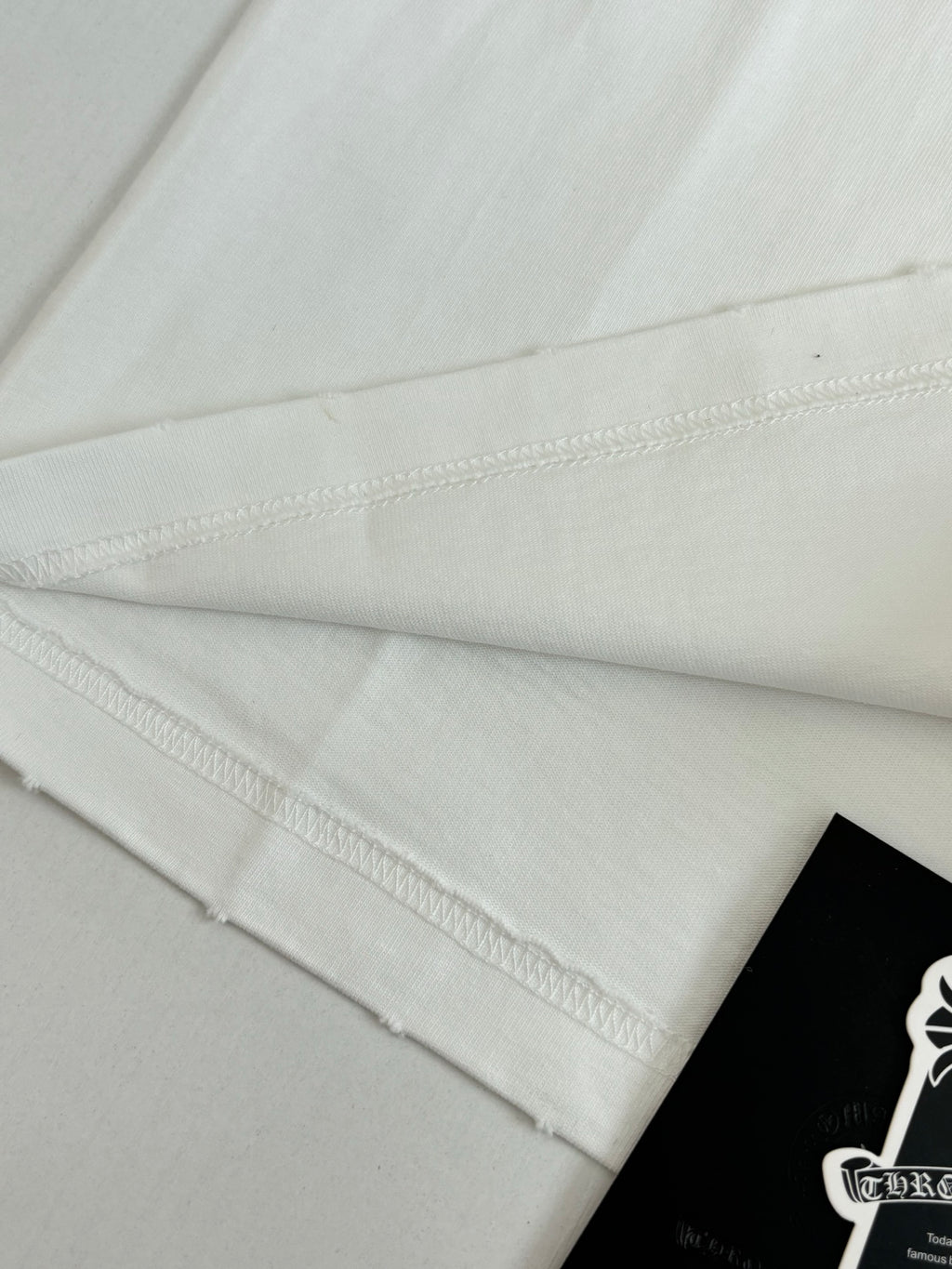 White T-shirt hem and side seam detail with small hanging label
