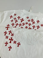 White T-shirt close-up with red pattern and embossed chest emblem detail