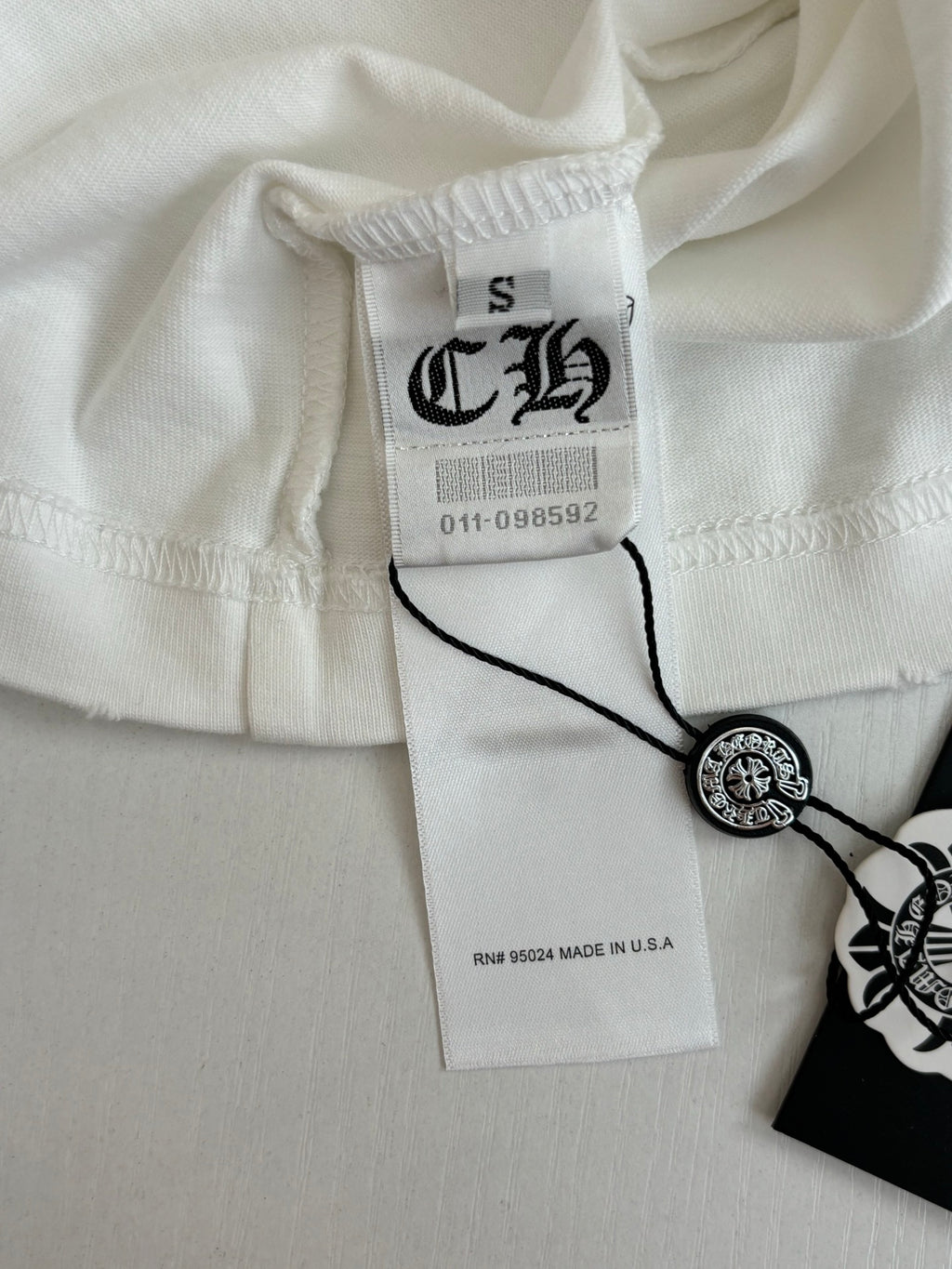 White short-sleeve crewneck T-shirt with brand tag and round logo button