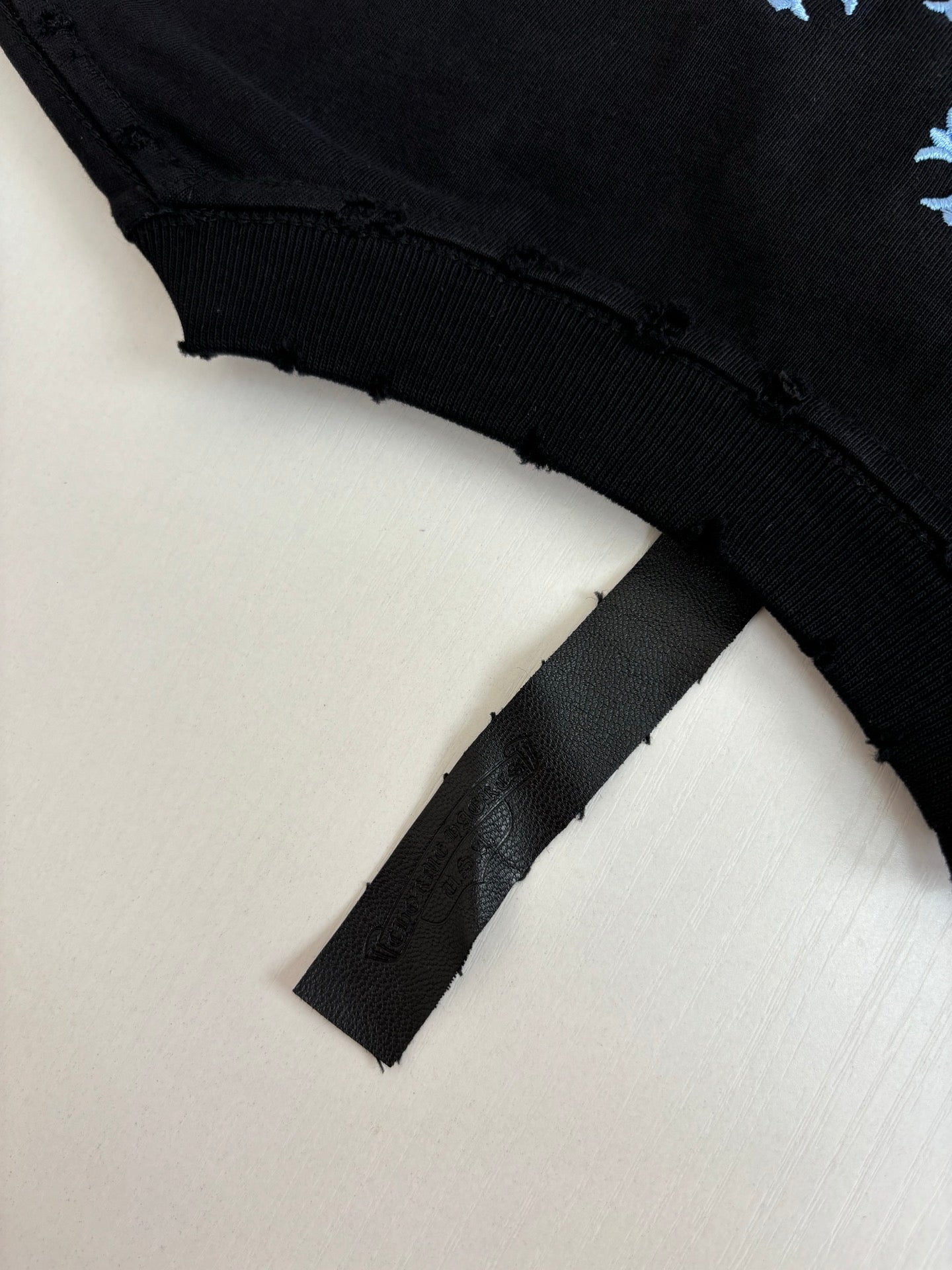 Black short-sleeve T-shirt sleeve cuff and folded hem detail