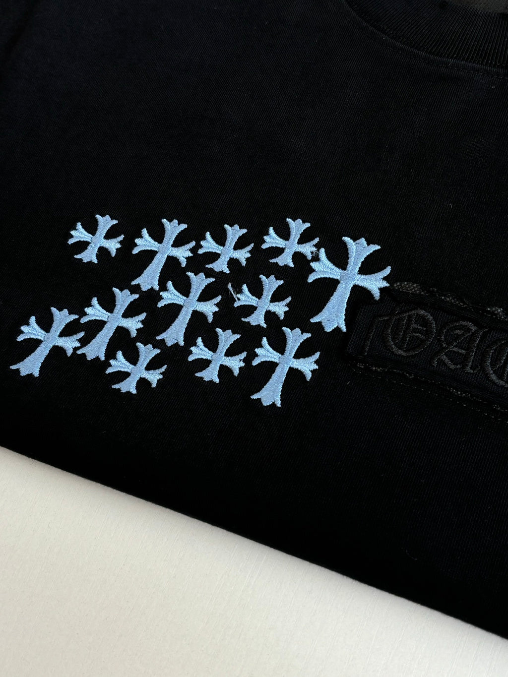 Close-up of black T-shirt fabric with blue snowflake logo