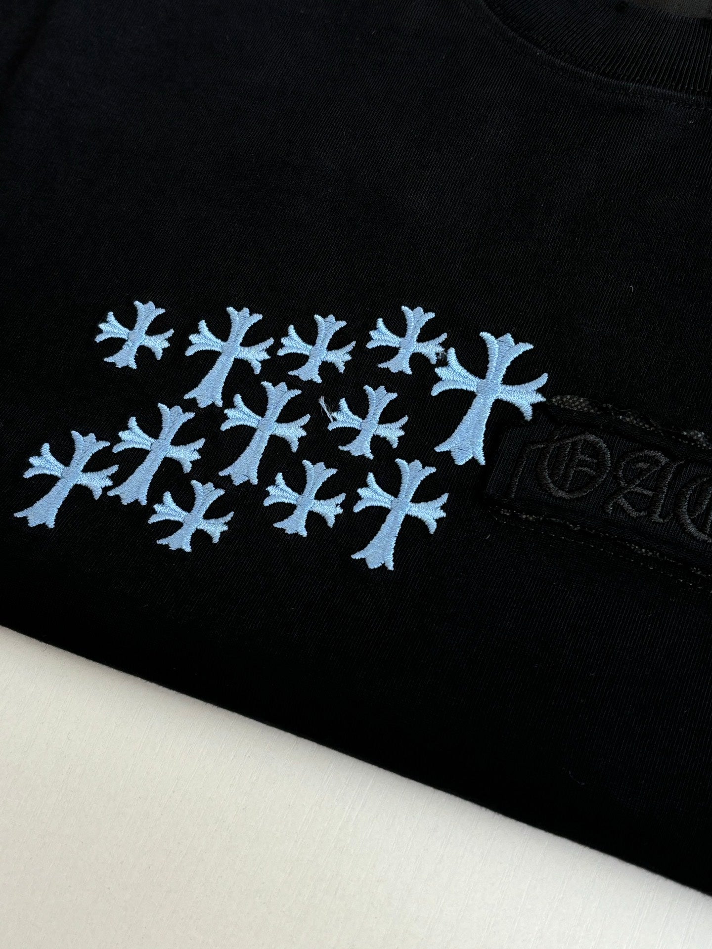 Close-up of black T-shirt fabric with blue snowflake logo