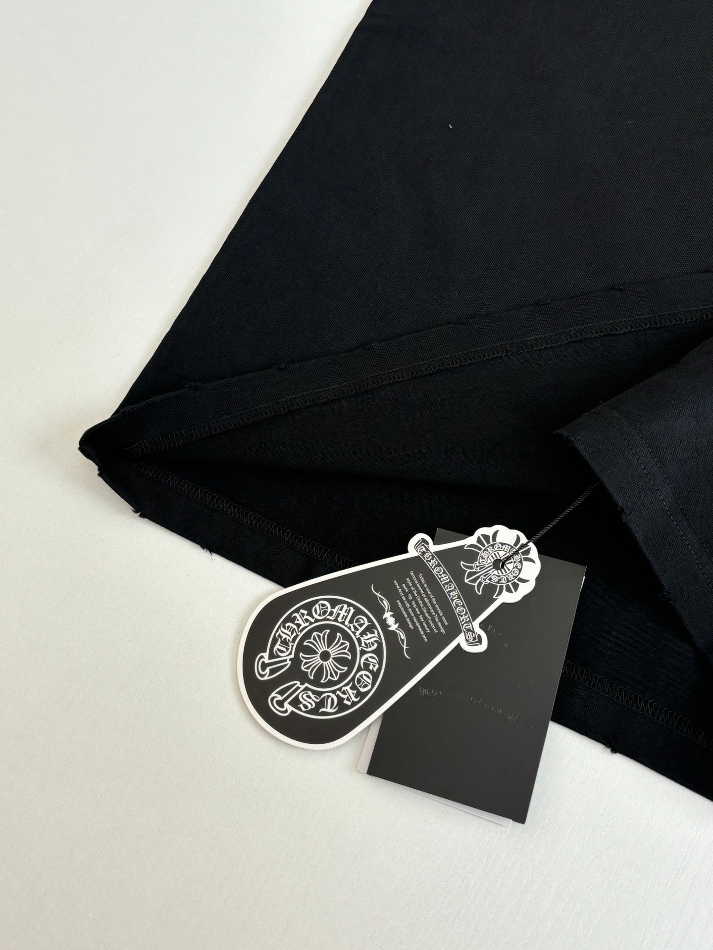 Black T-shirt corner with stitched seam and hanging hangtag