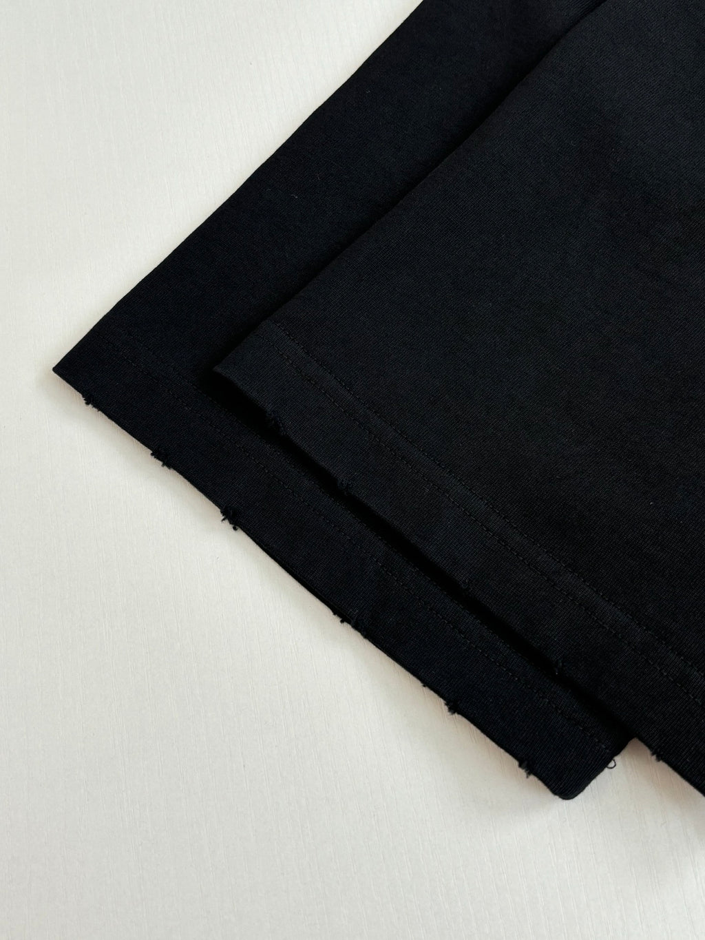 Folded black short-sleeve T-shirts stacked together