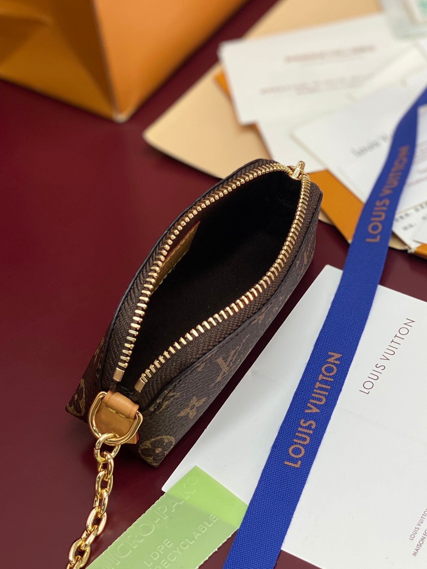 Small monogram pouch with open zip top and gold chain hardware