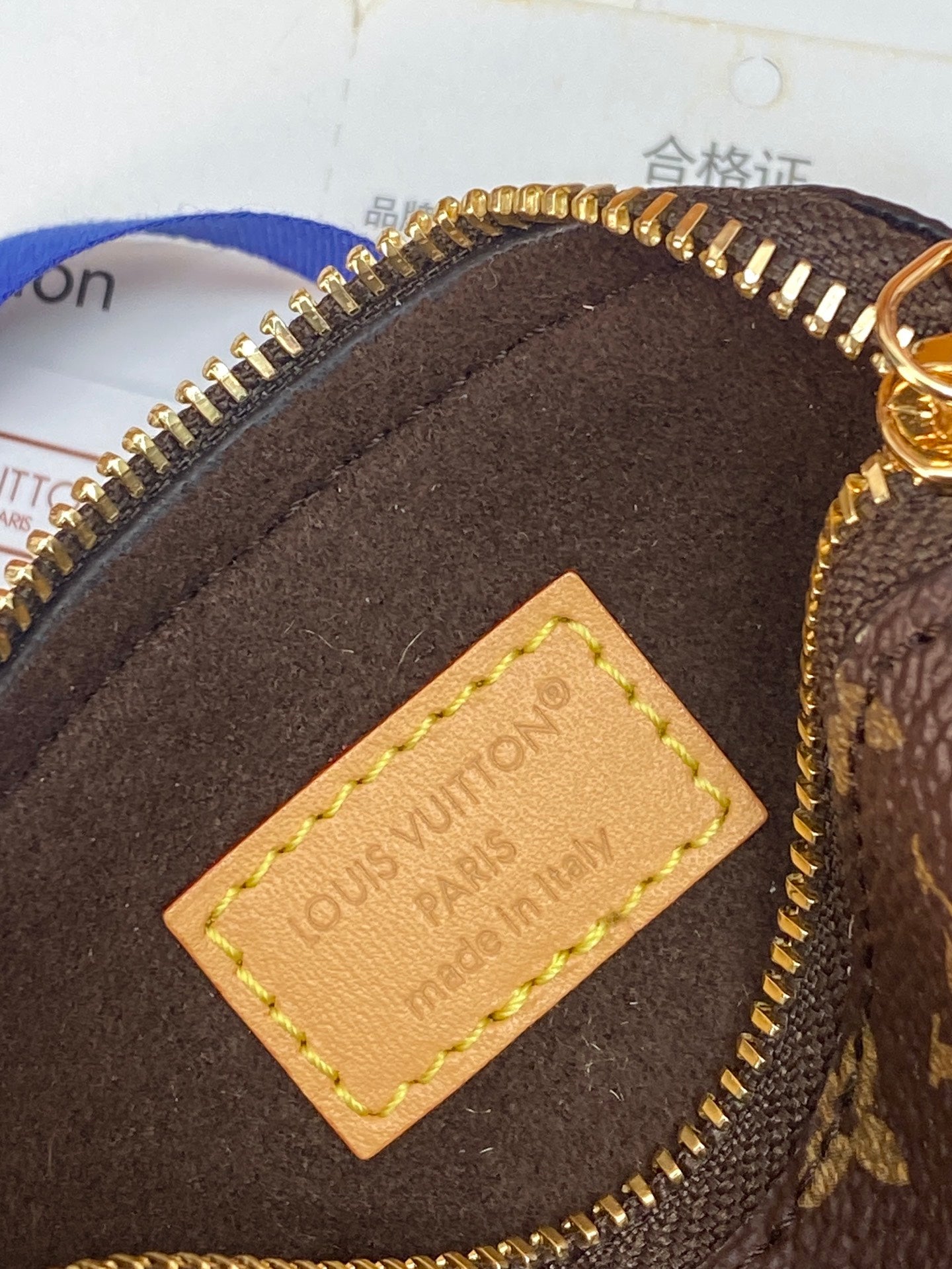 Close-up of monogram pouch interior tag with stitched leather patch