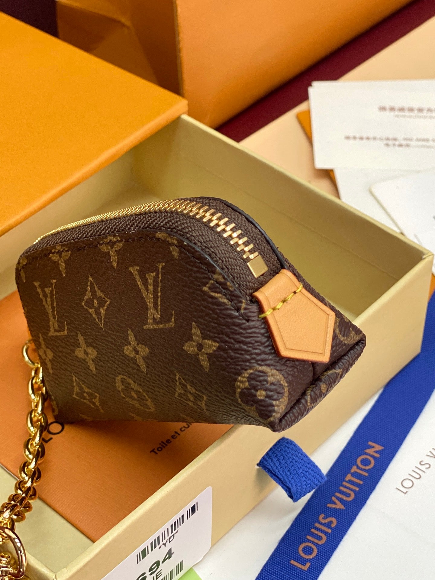 Louis Vuitton monogram wristlet pouch with tan leather tag on front