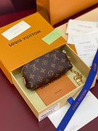 Small monogram pouch with gold chain strap and zippered top opening