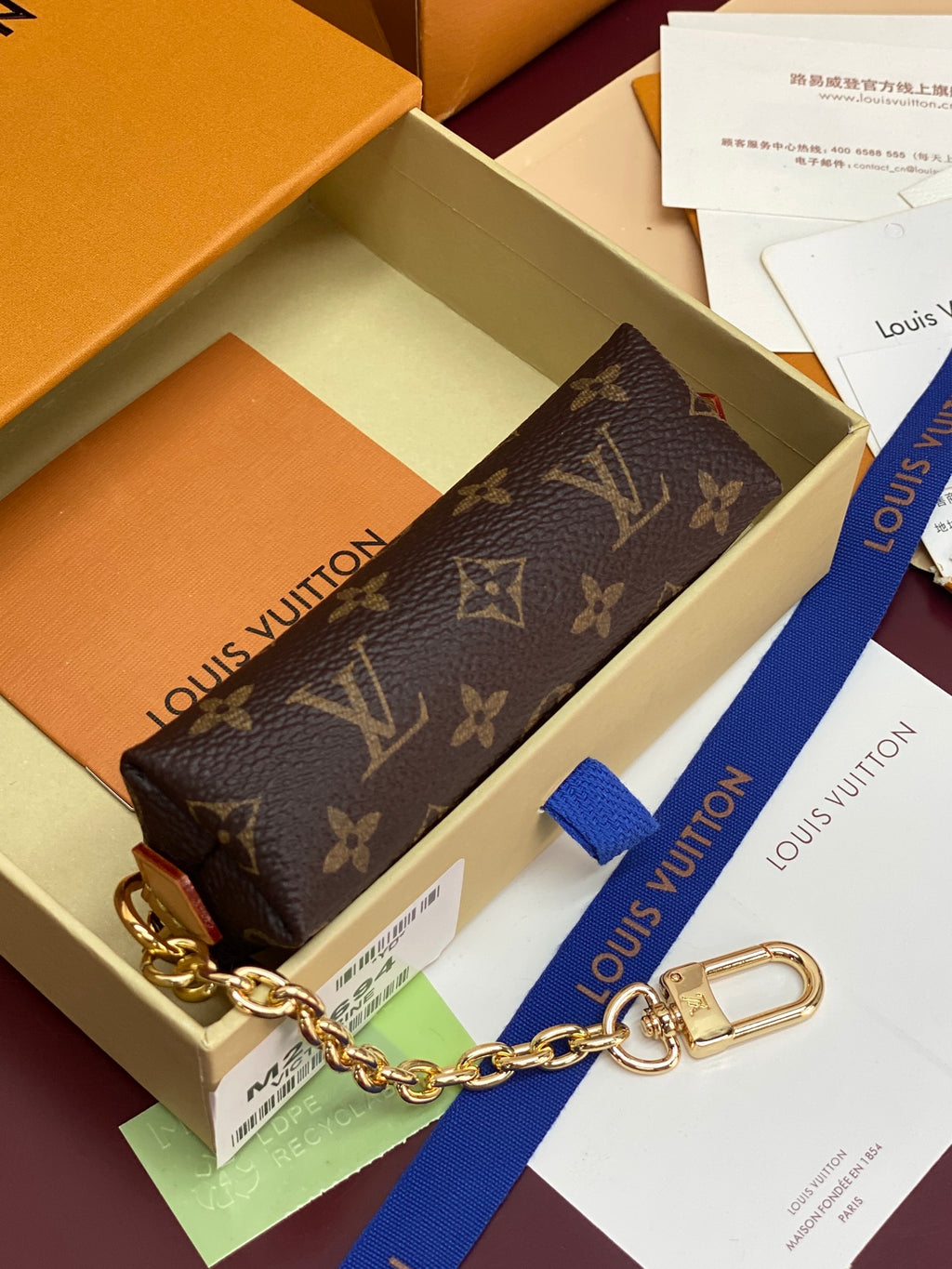 Monogram canvas small pouch with gold chain and zip closure on display box