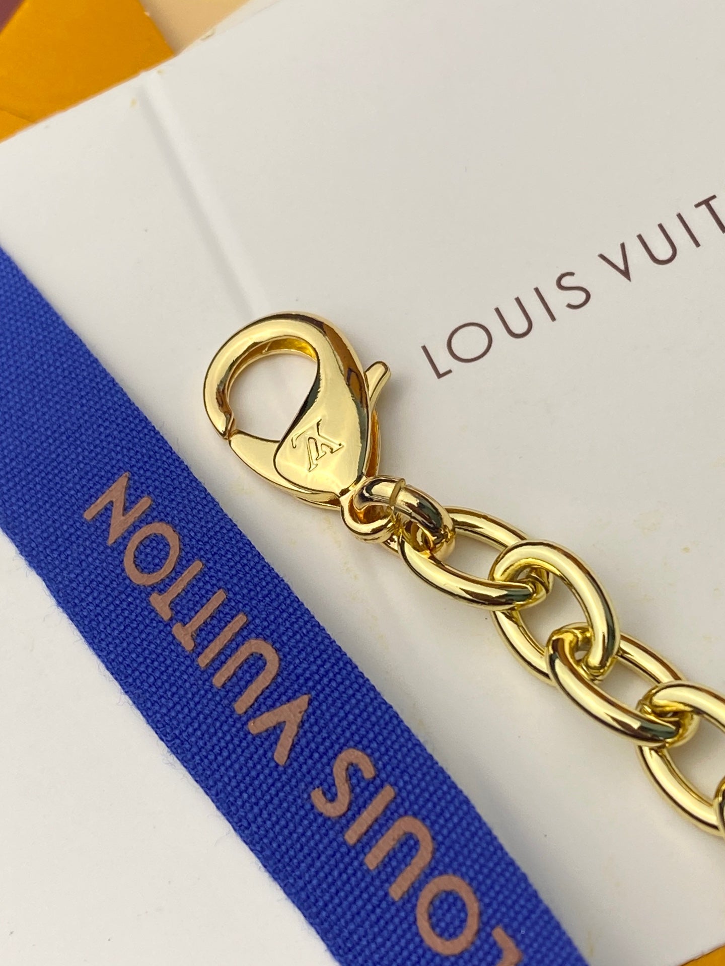 Small handbag key-ring chain with gold hardware on blue strap