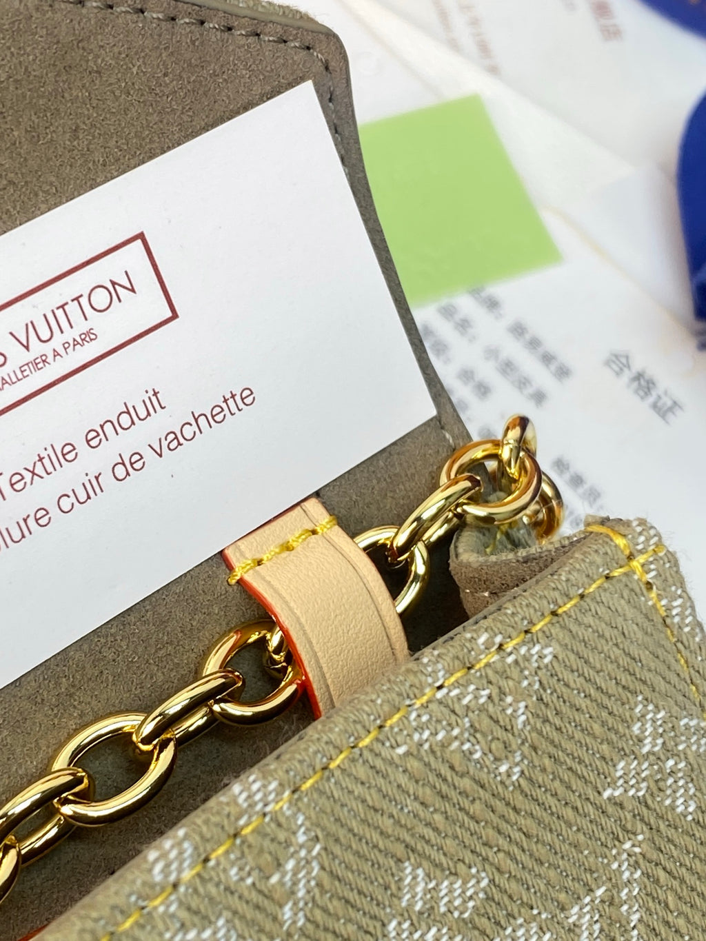 Louis Vuitton bag chain with beige leather strap on green patterned canvas