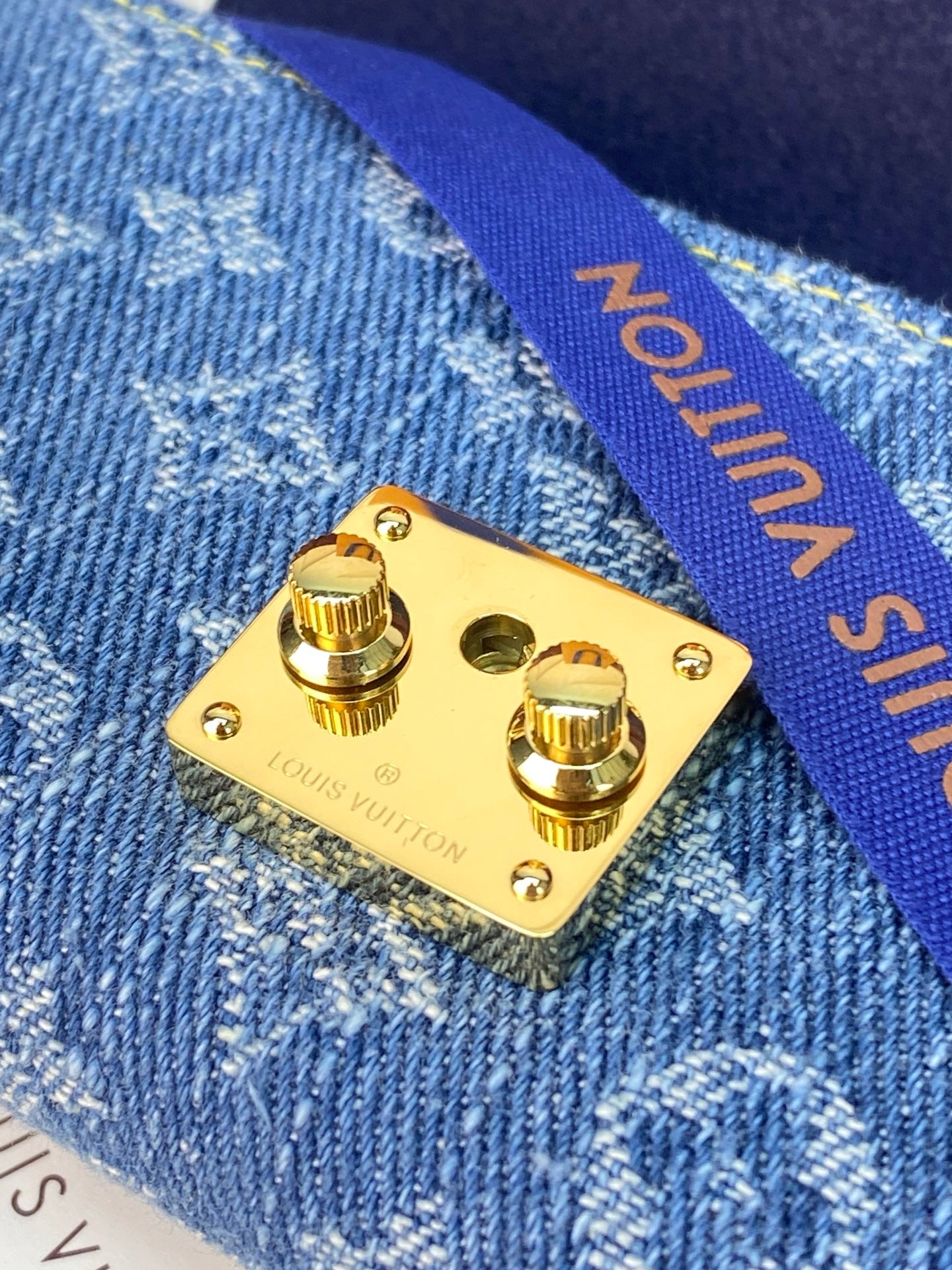 Louis Vuitton small bag gold snap hardware plate on blue denim