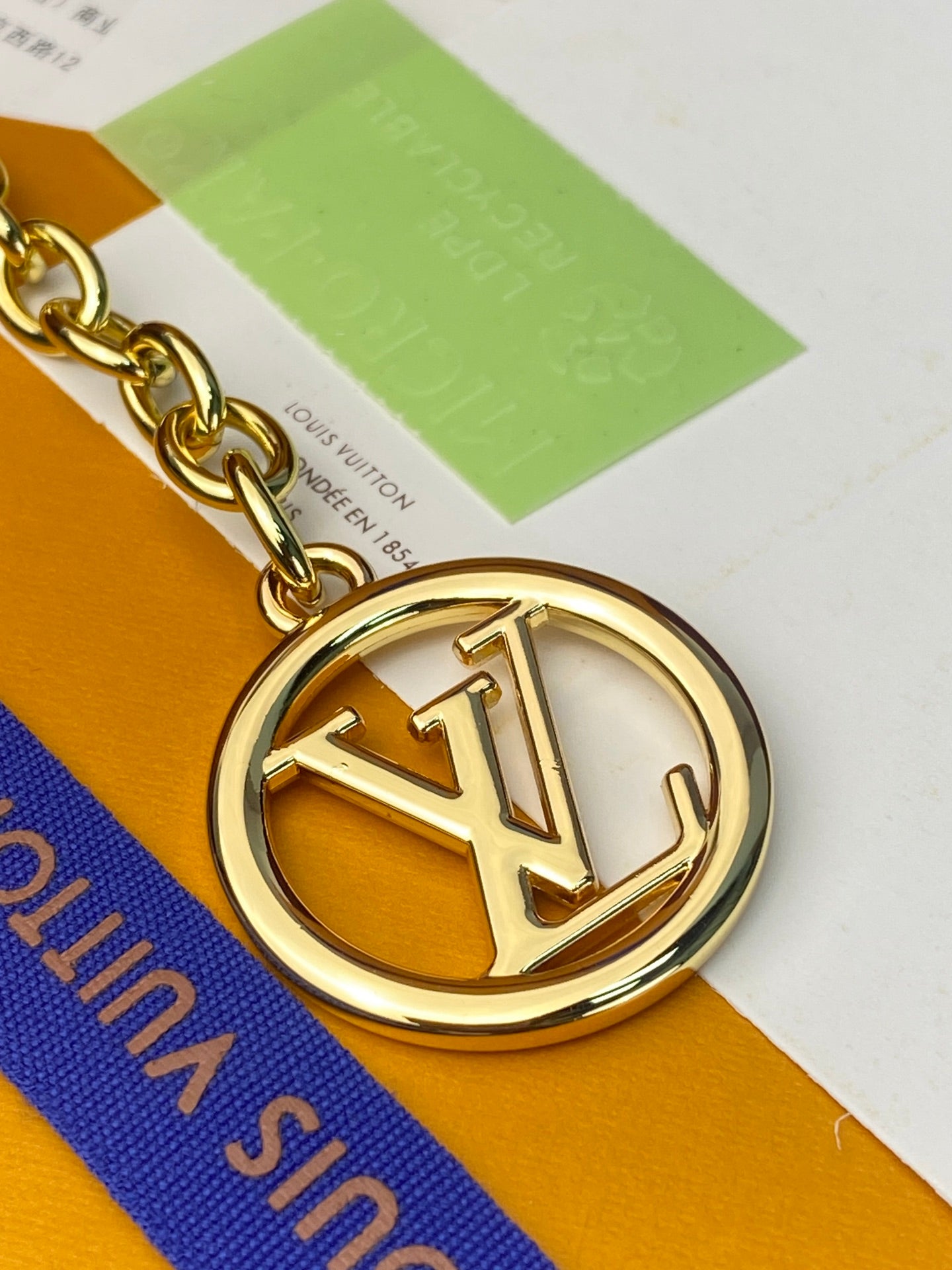 Louis Vuitton bag gold LV emblem on chain with blue and tan coated strap
